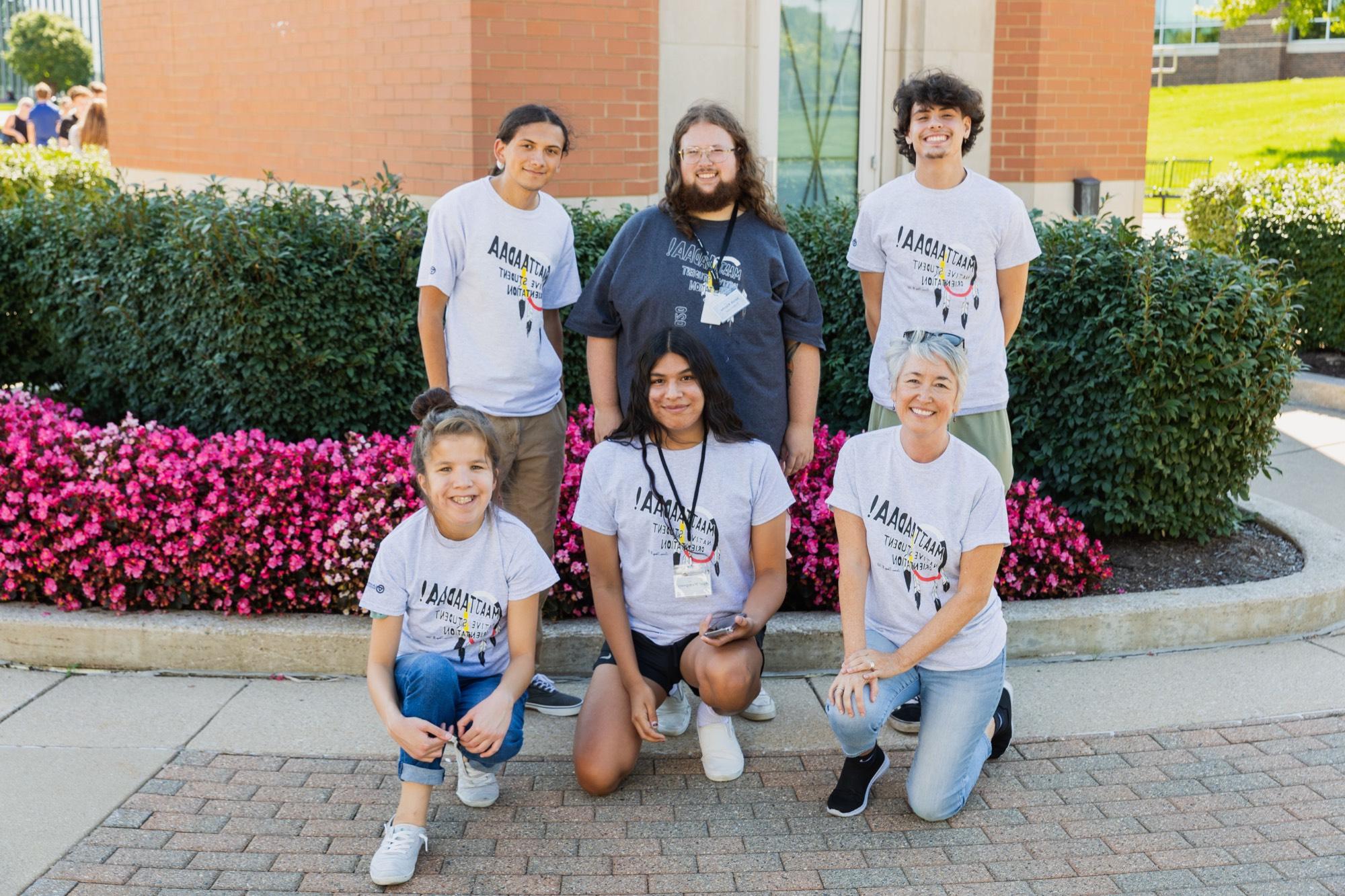 6 members during the orientation standing in front of a clocktower on GVSU campus